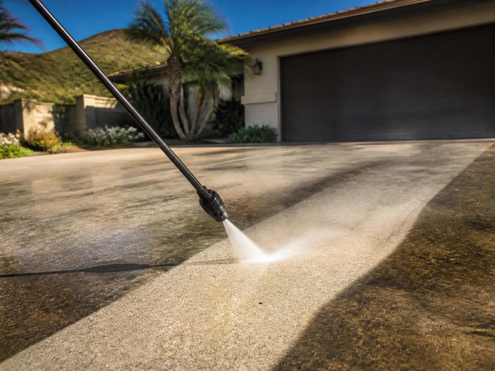 Pressure washing a dirty driveway clean